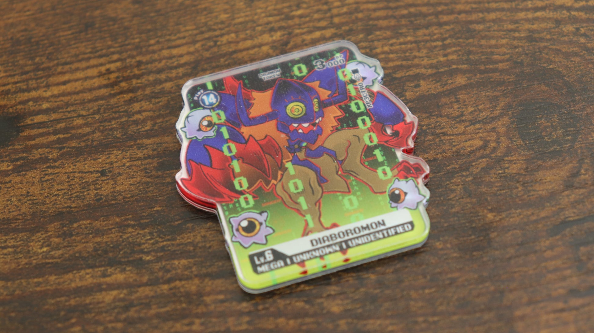 Diaboromon acrylic token for the Digimon Card Game, shown in a close-up product photo with green digital code background and character art on a clear acrylic token.