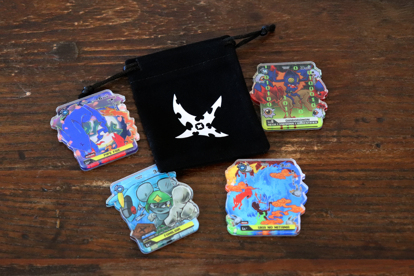 Velvet drawstring bag holding acrylic Digimon Card Game tokens, shown as a bundled accessory set for TCG play and storage.