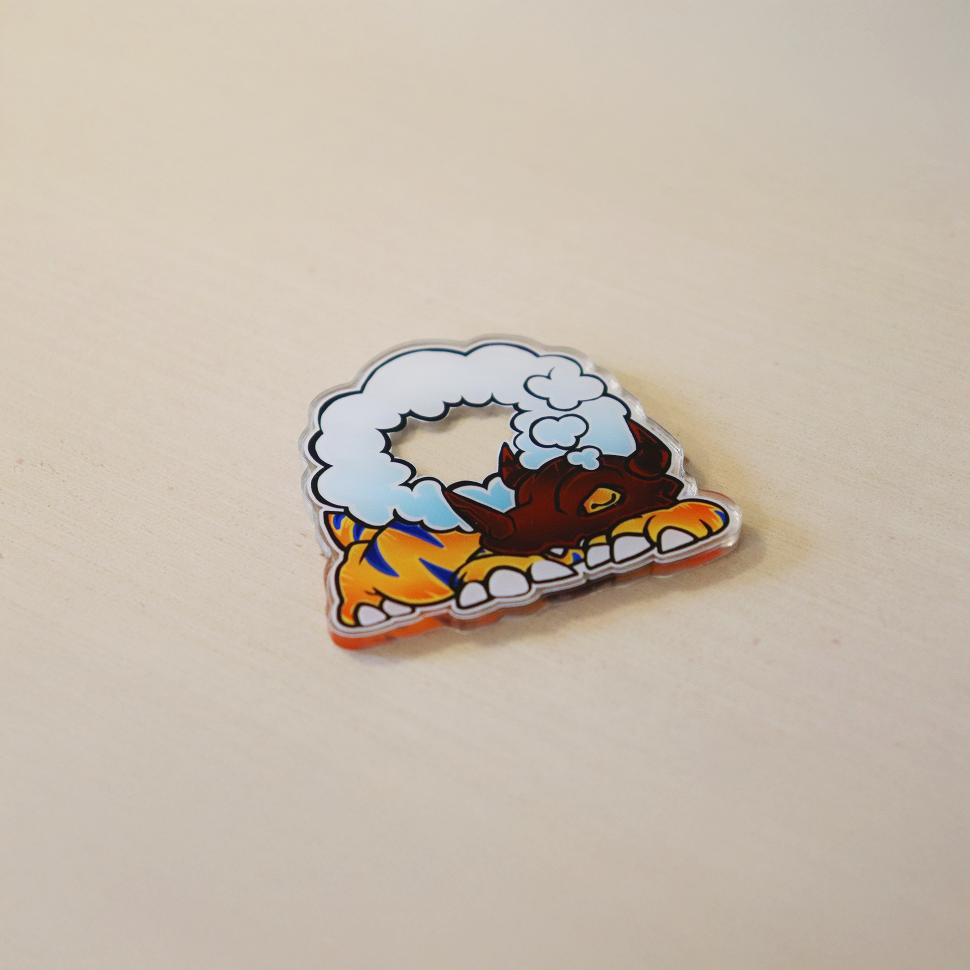 Sleepy Greymon acrylic memory marker for Digimon TCG, chibi-style monster curled up under a fluffy cloud pillow with clear glossy acrylic on a tabletop product photo.